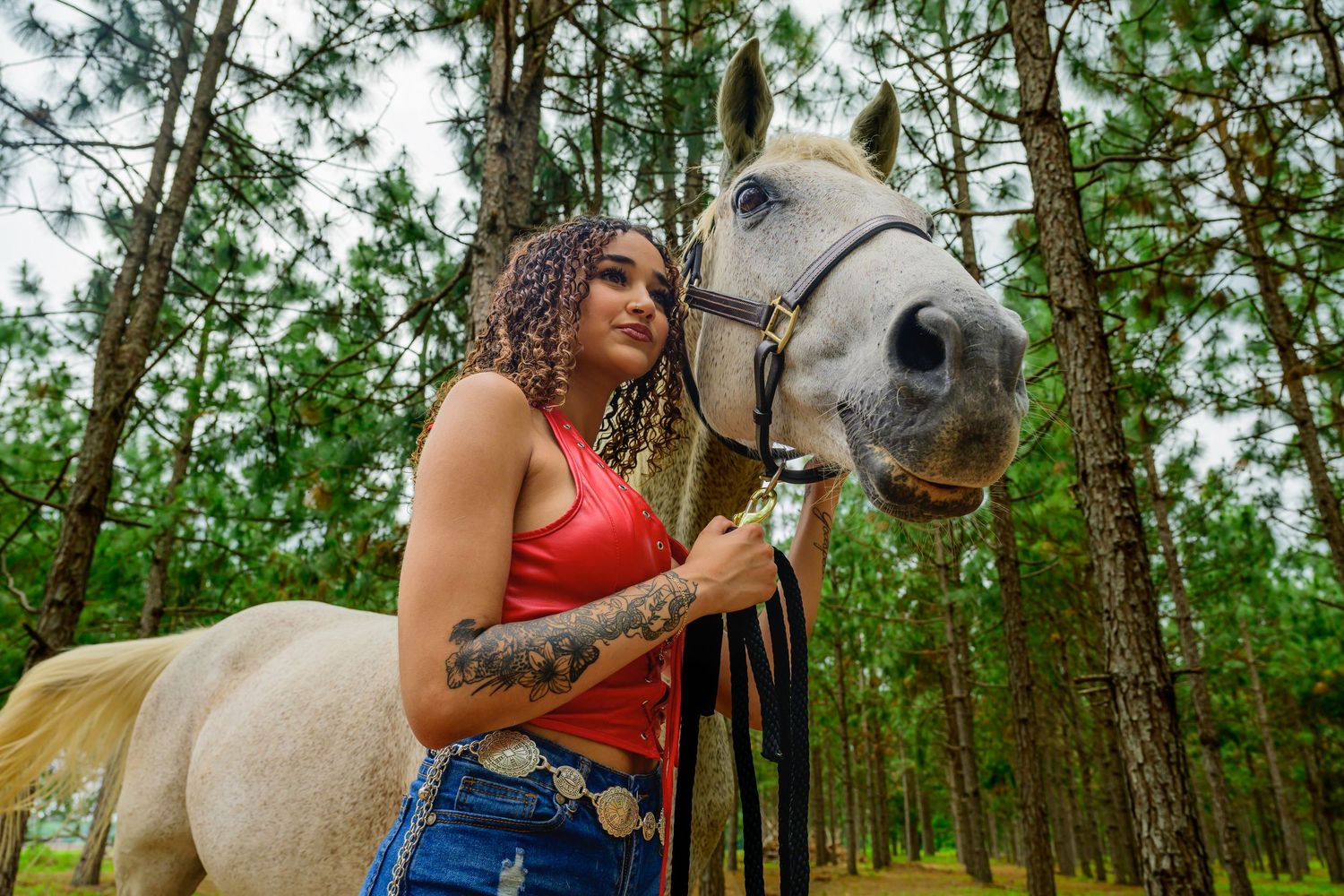 Outdoor lifestyle portrait of a woman with a horse in a natural setting
