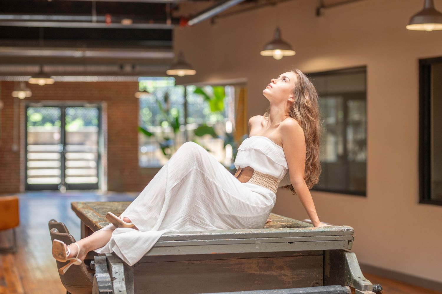 Outdoor editorial portrait of a woman in a white dress in a natural setting