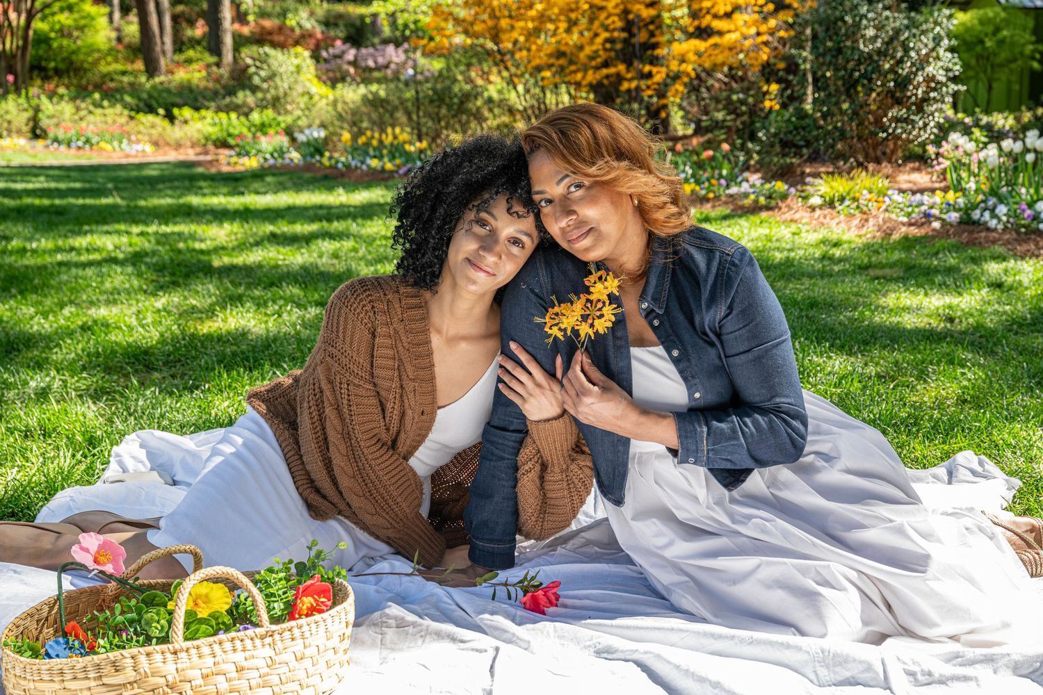Outdoor mother and daughter portrait of the two women enjoying a picnic in a garden setting in Raleigh, NC
