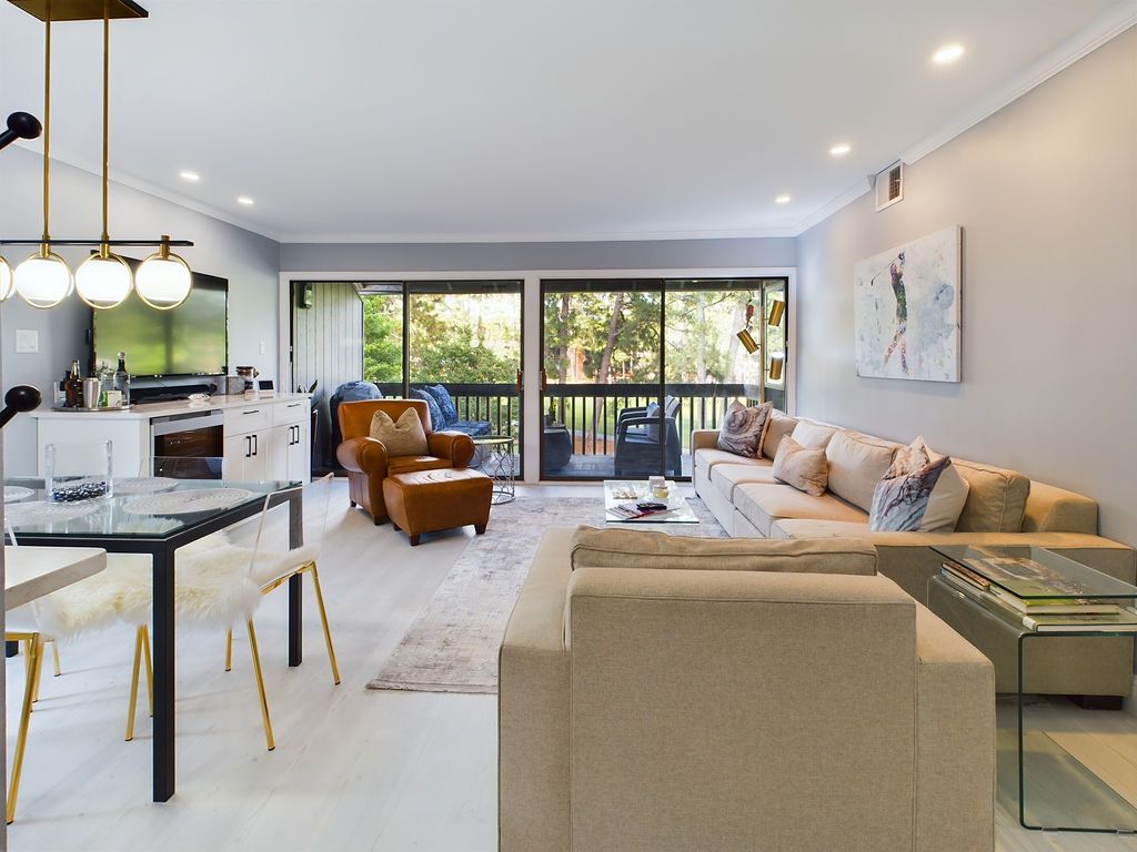 Modern open concept living room and dining area In Southern Pines with tan sofa. Professional Real estate Photography by D2lifephotography