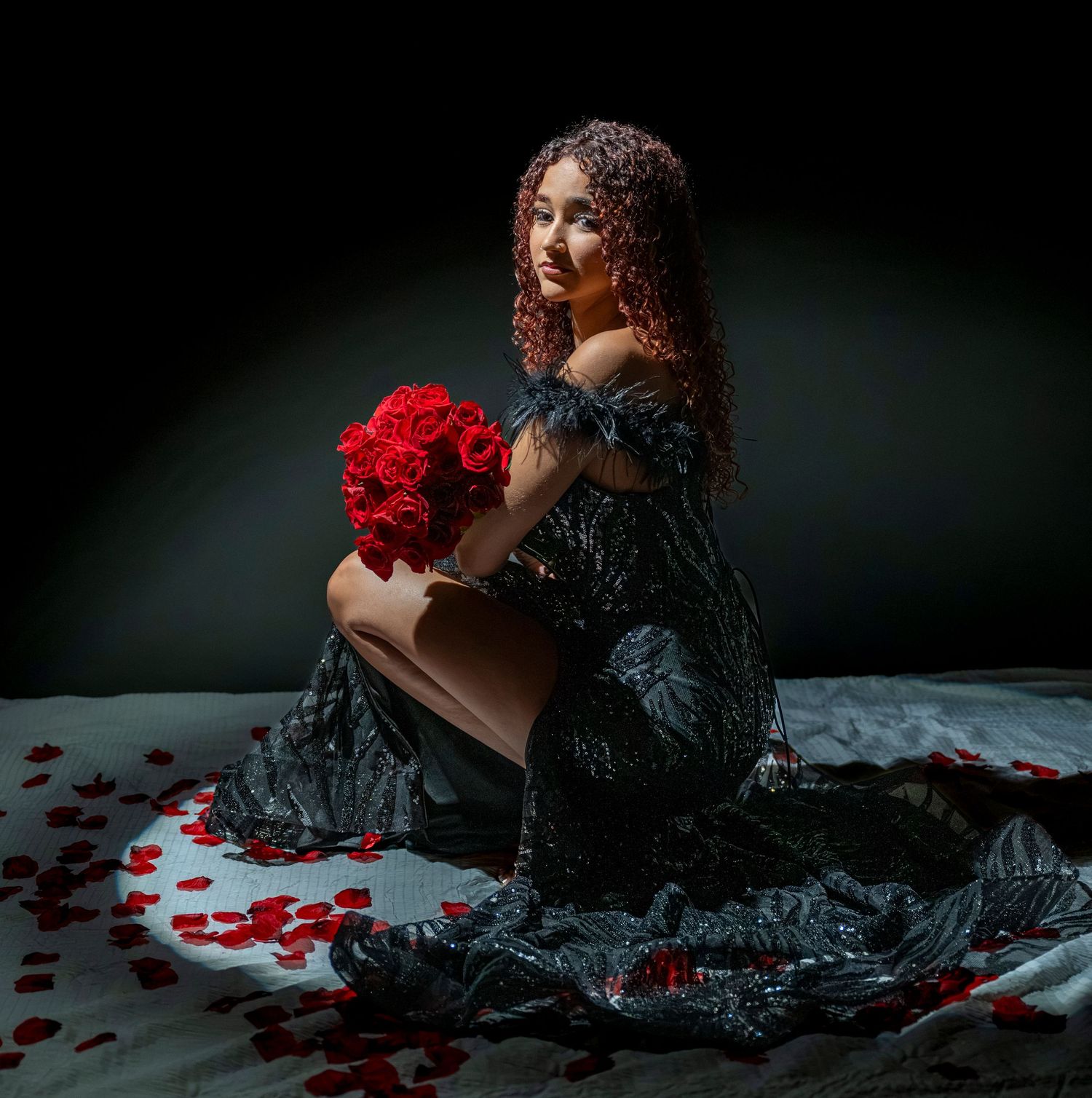 Creative editorial portrait of a woman in a black dress with red roses