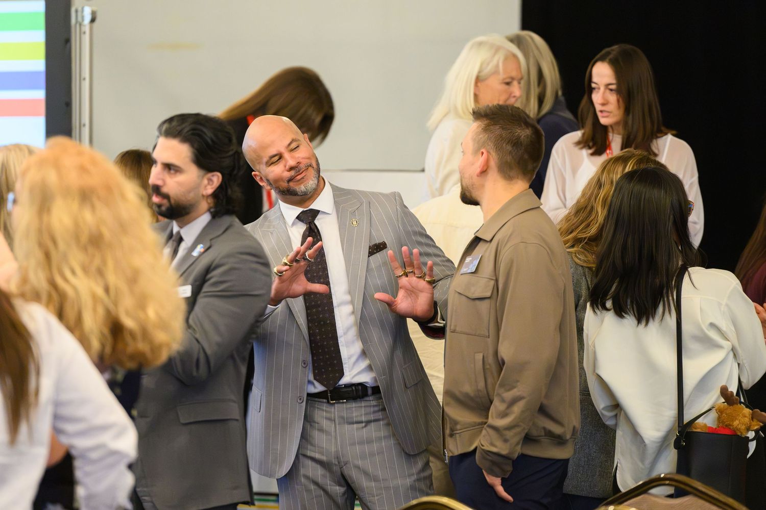 Business professionals networking at a corporate event, engaged in lively conversation in a conference room.