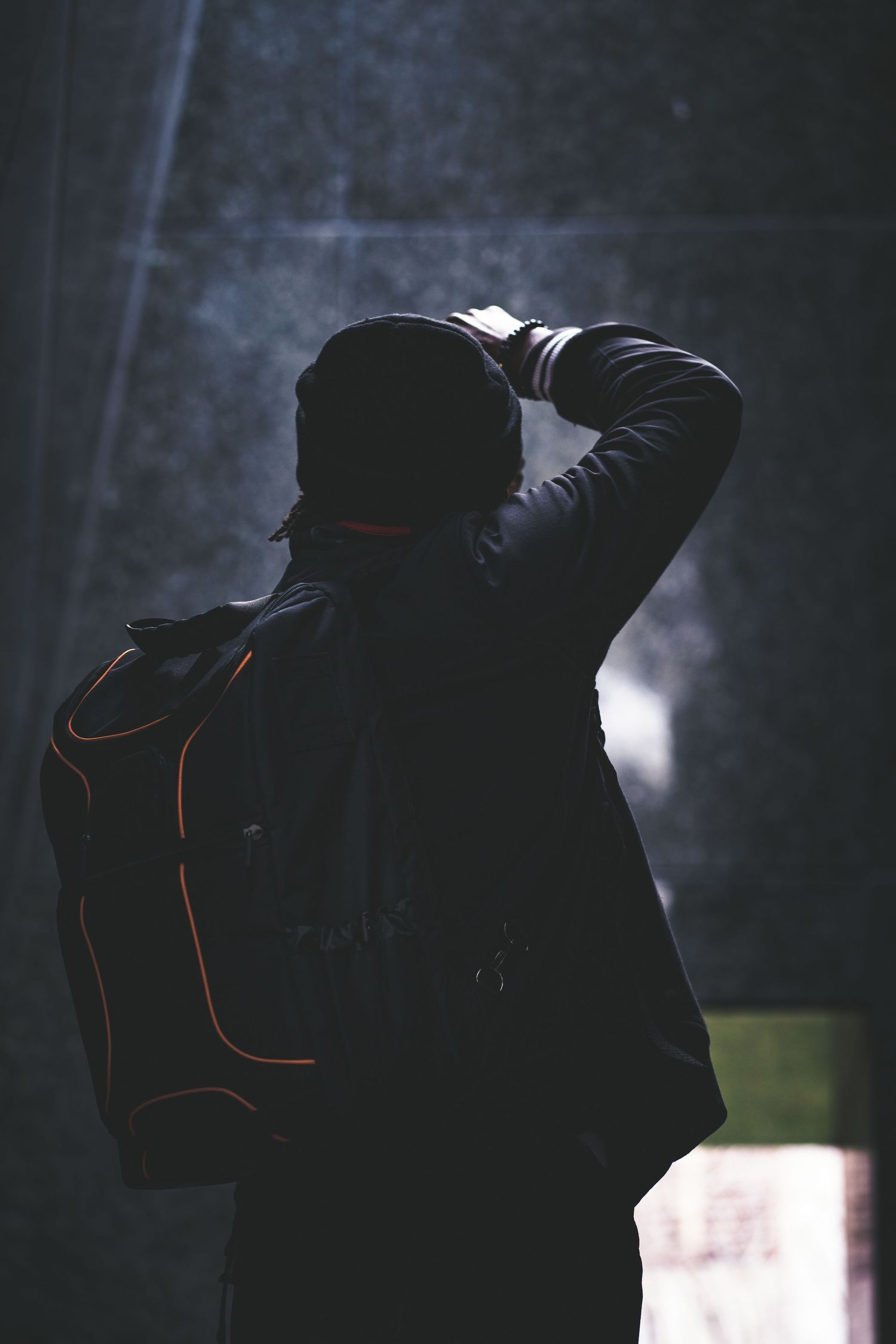 Photographer taking a photograph with a professional camera while wearing a backpack