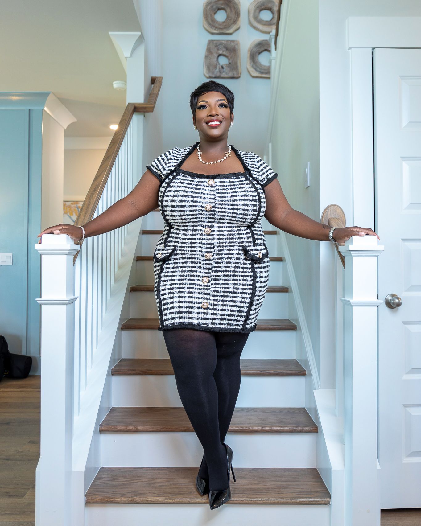 Personal branding portrait of a real estate professional posing on a home staircase