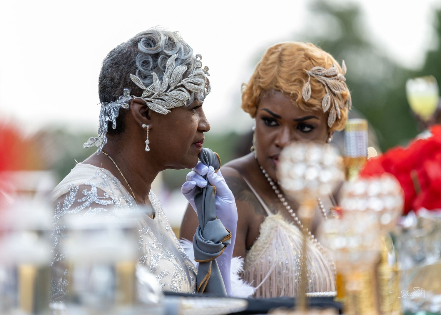 Two elegantly dressed women sharing a moment at a decorated celebration table