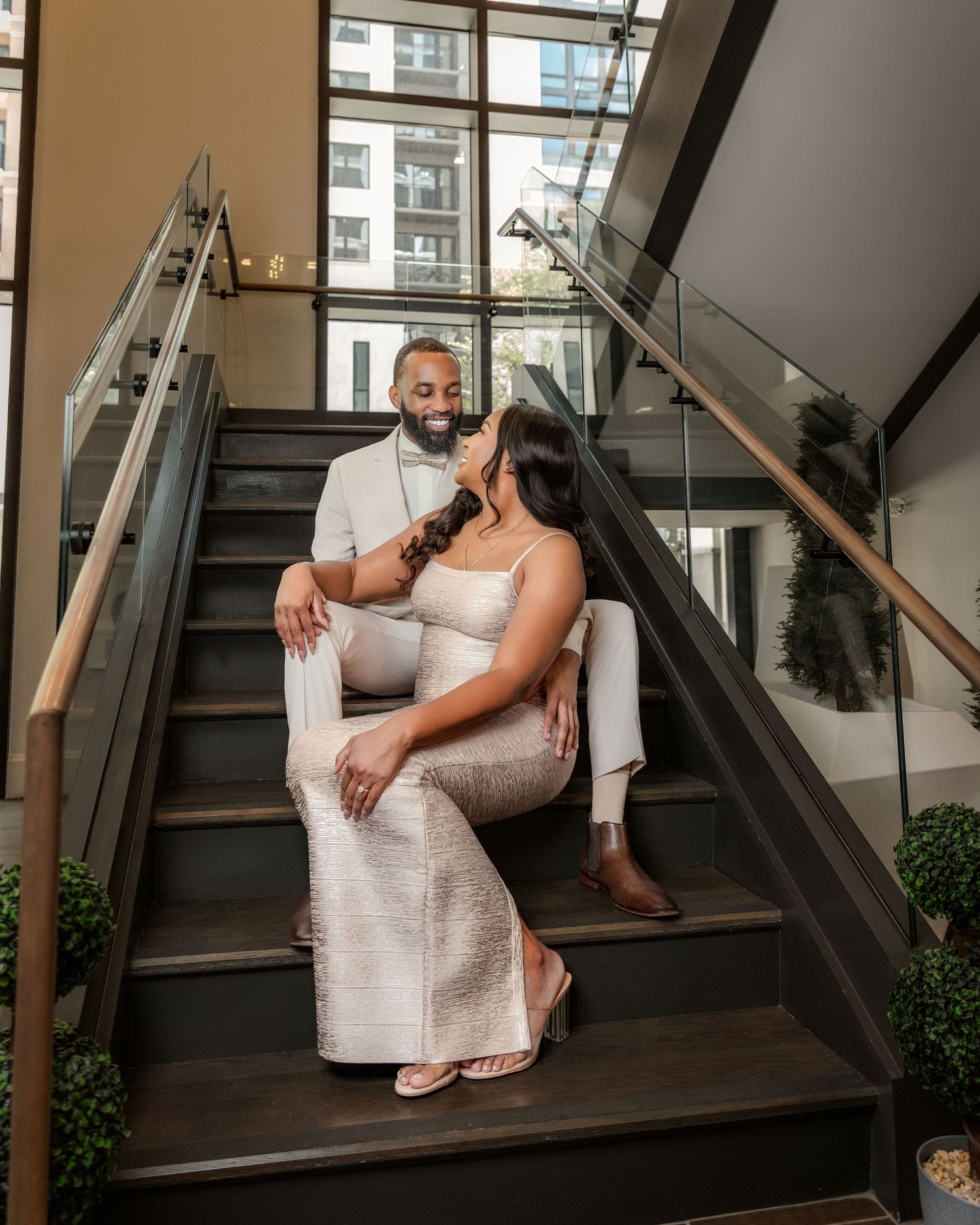 Couple seated together on a modern staircase during an elegant engagement portrait session