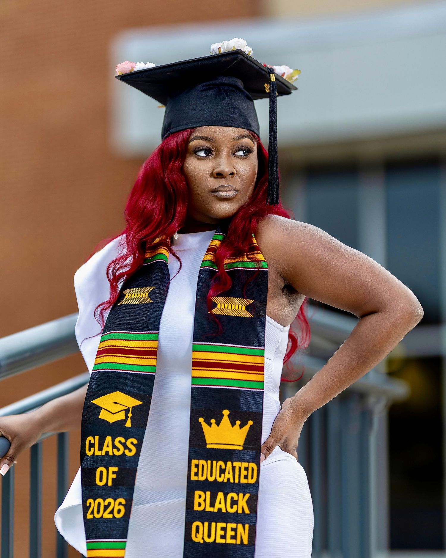 College graduate wearing a decorated cap and colorful graduation stole during a portrait session