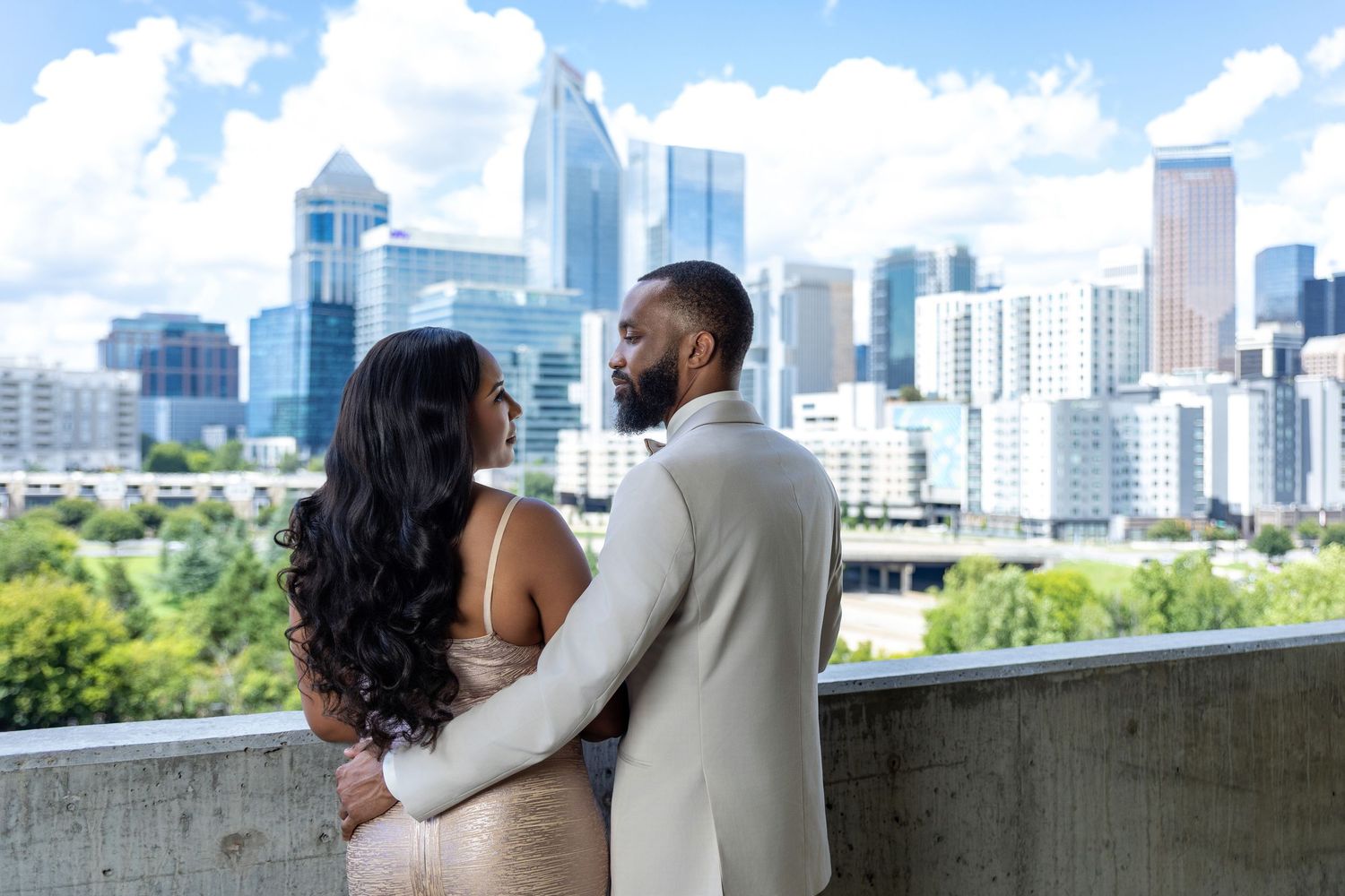 Couple standing together on a balcony overlooking a city skyline