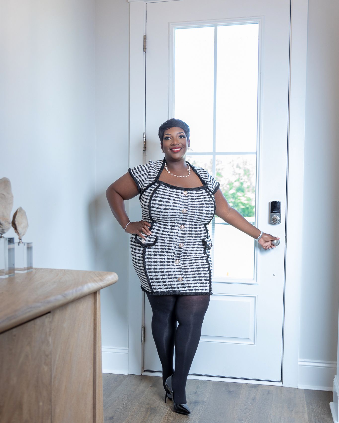 Personal branding portrait of a real estate professional standing at the entrance of a home