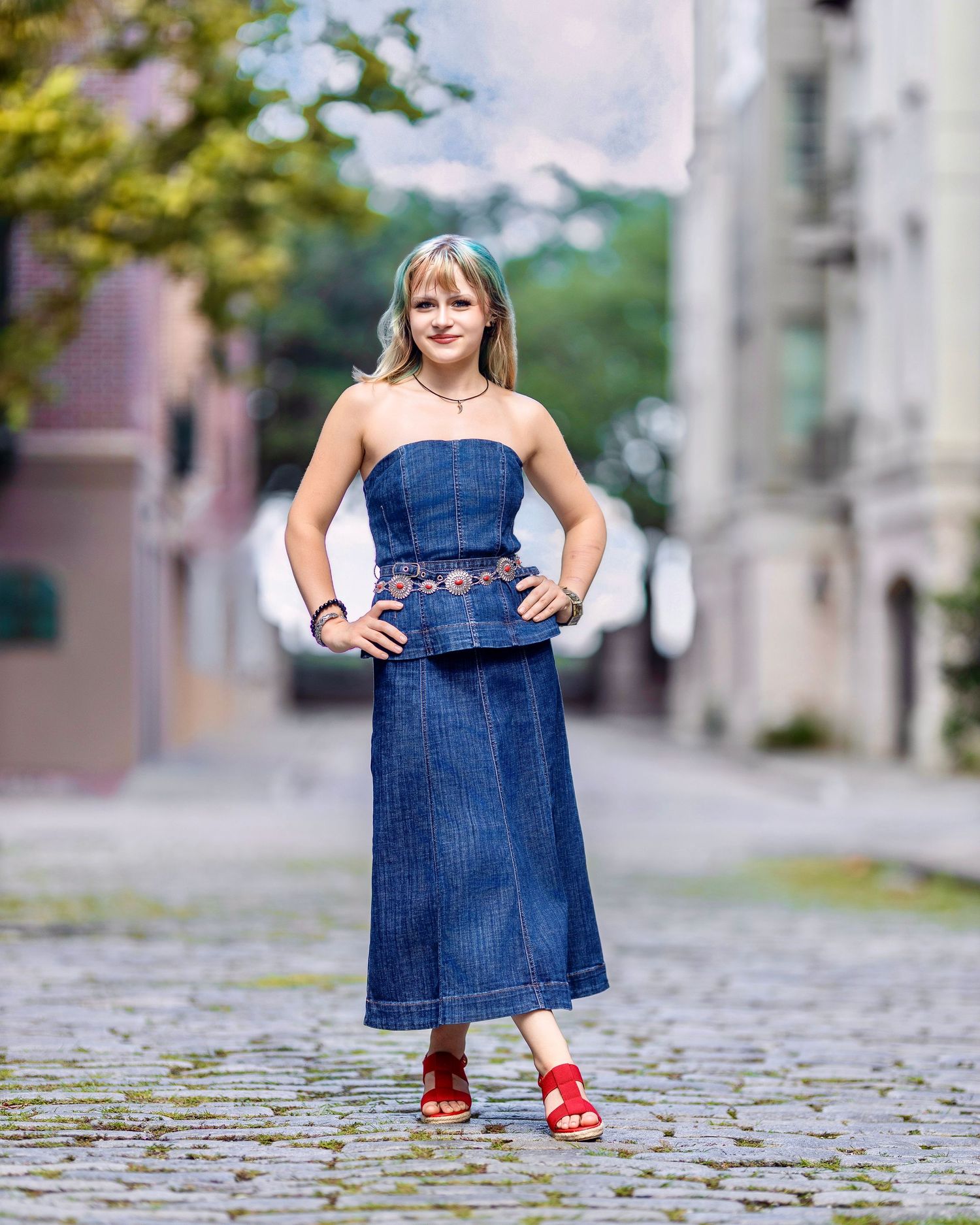 High school senior posing in a denim outfit on a cobblestone Charleston street
