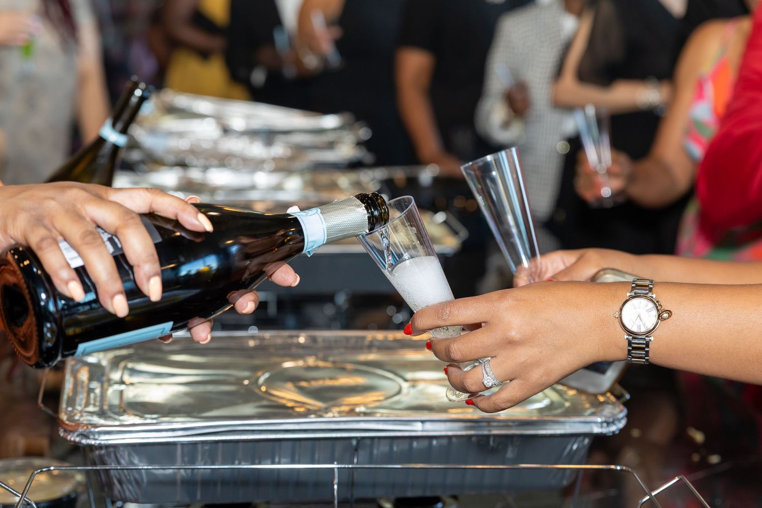 Bartender pouring champagne into a glass at a festive celebration event.