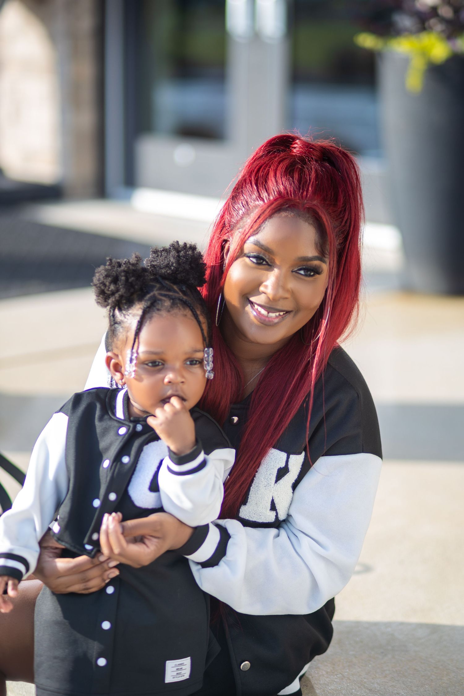 Smiling mother holding her young daughter during an outdoor portrait session