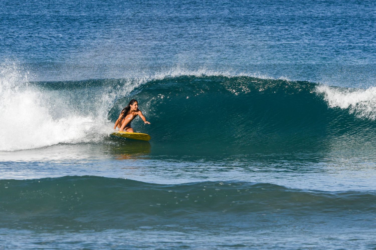 Surfer riding a wave at Playa Avellanas, Costa Rica
