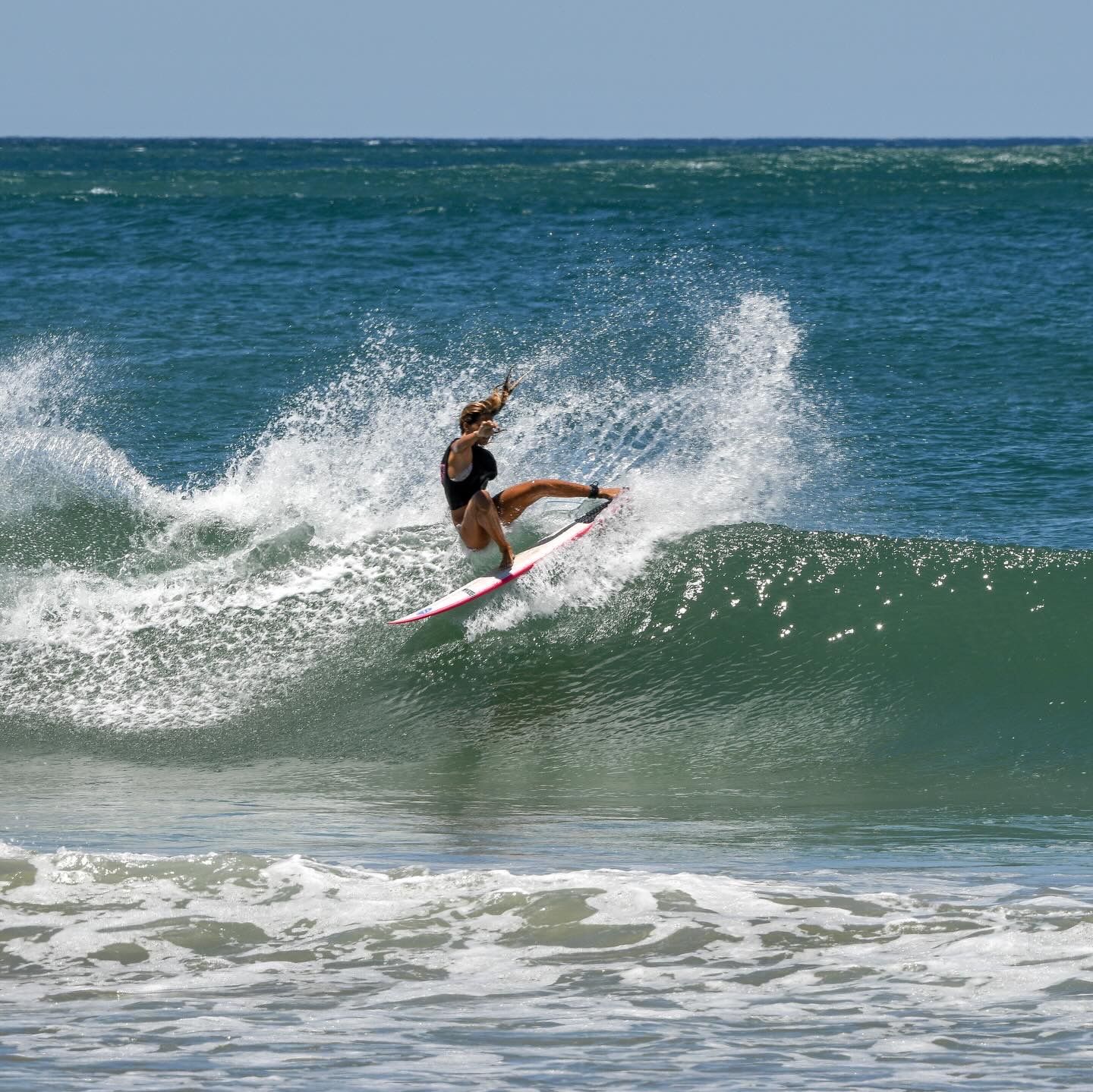 Surfer riding a wave at Playa Avellanas, Costa Rica