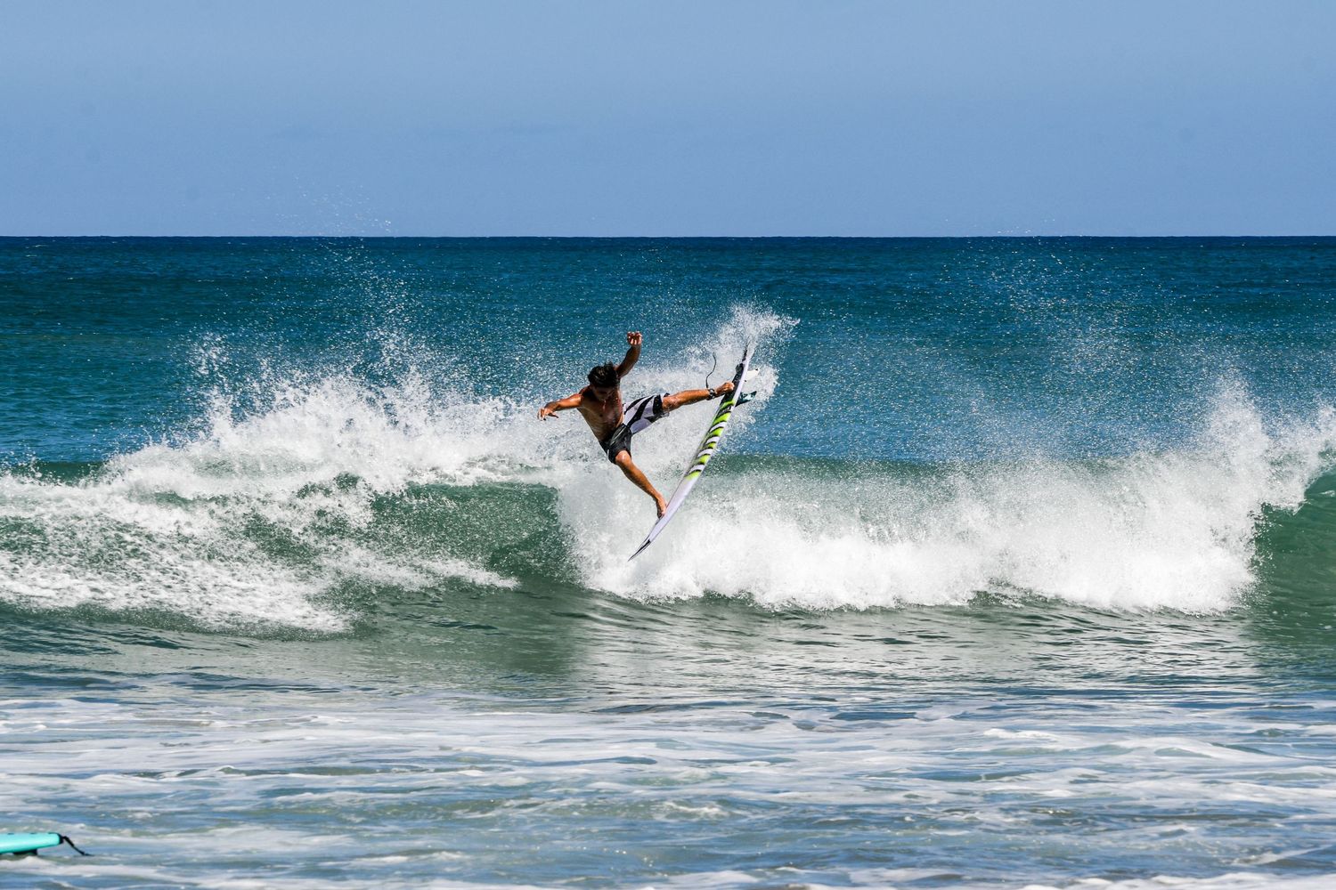Surfer riding a wave at Playa Avellanas, Costa Rica