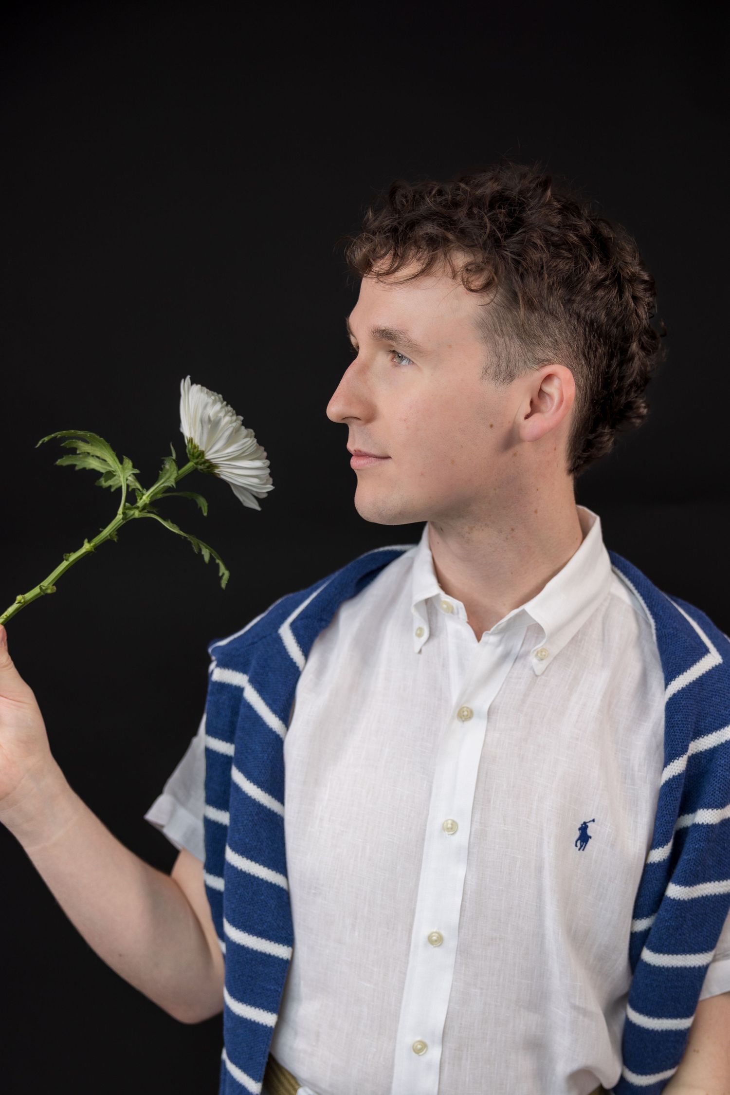 A series of artistic portraits showing someone holding a white flower against a dark background.