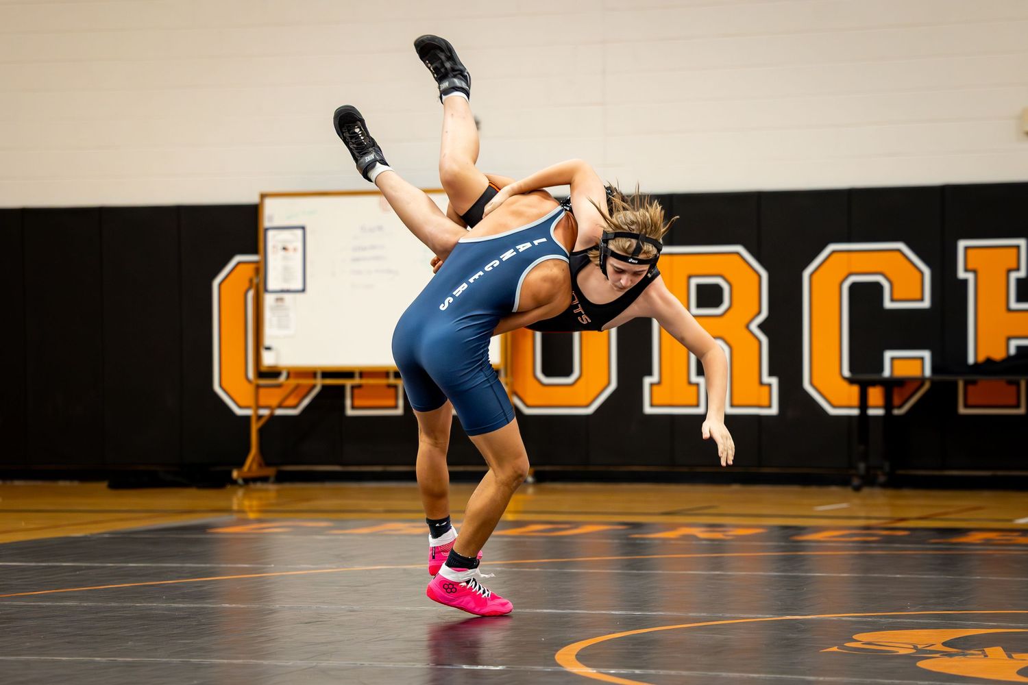 Wrestlers grapple during a competitive match on the mat. Studio portrait of a youth athlete. Team photos.