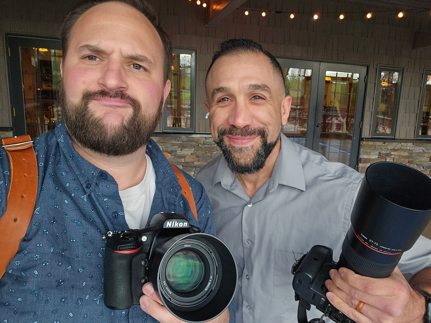 Group of photographers display professional camera equipment while meeting indoors.