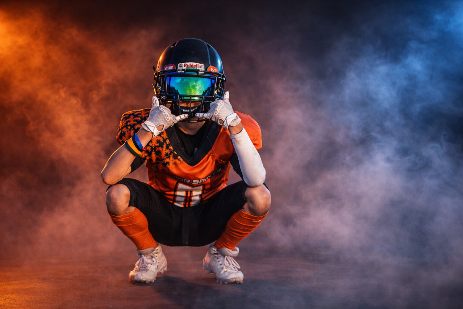 Football players pose dramatically with orange and blue smoke effects on field. Studio portrait of a youth athlete. Team photos.