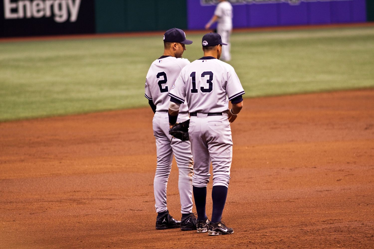 Two baseball players having a conversation on the infield during a game.