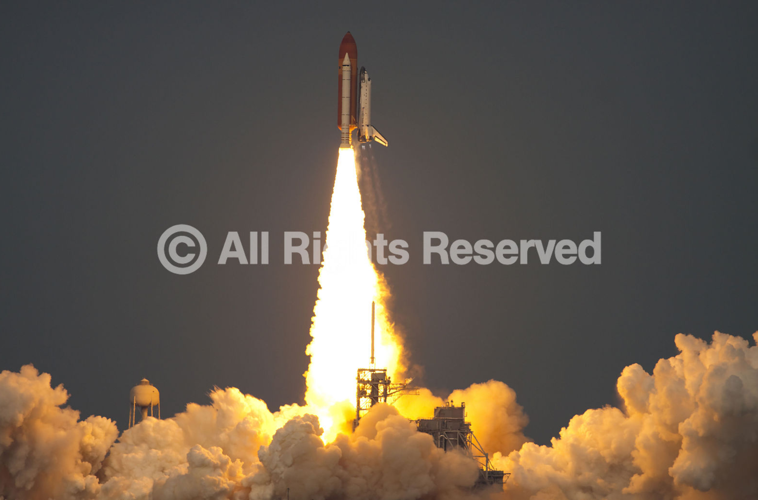 Space shuttle launches into the sky with bright orange flames and billowing white exhaust clouds against a dark background.