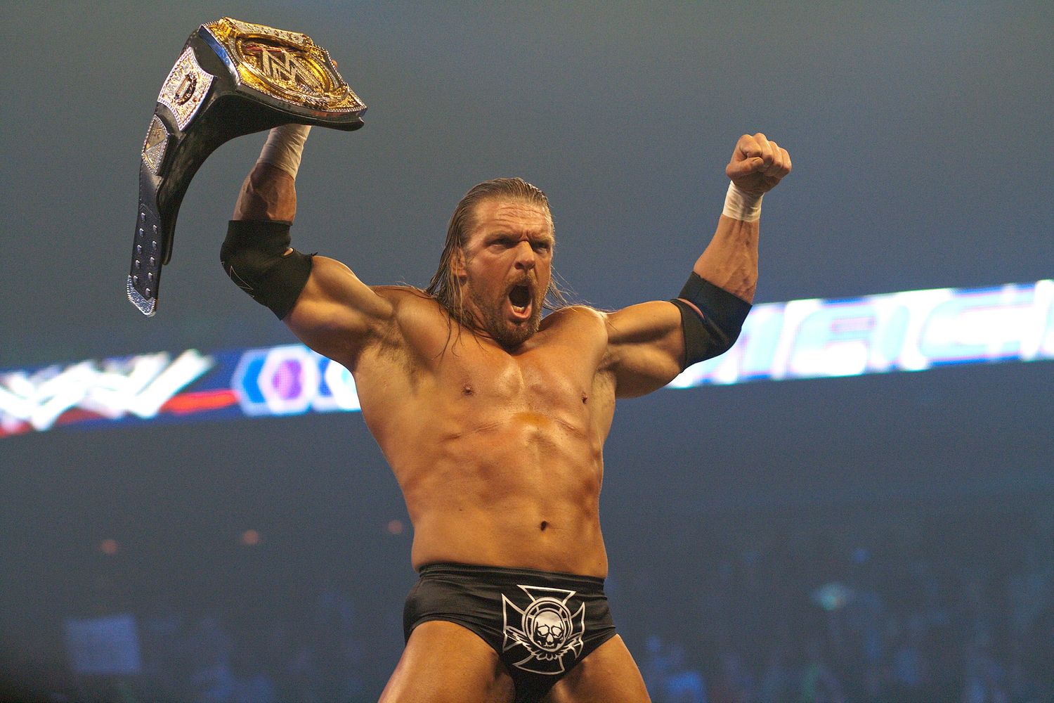 Professional wrestlers celebrate and pose victoriously in a wrestling ring during an intense match sequence.