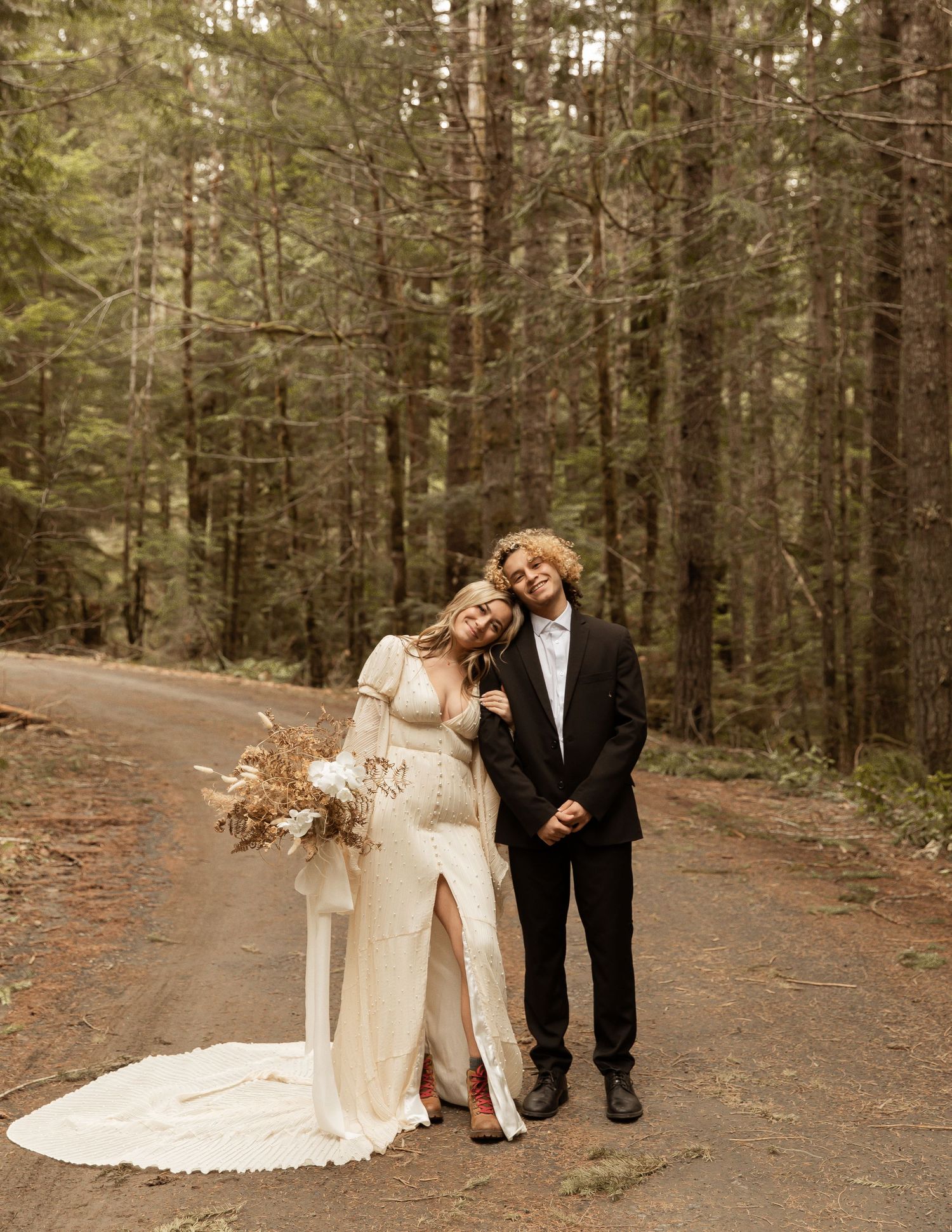 Bride and groom sharing intimate moment on forest path.