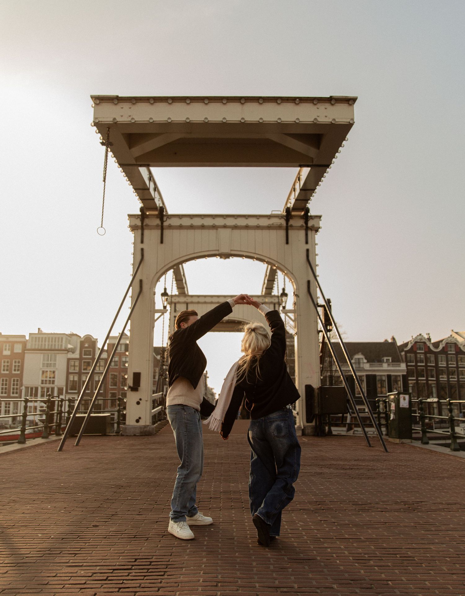 A series of five sepia-toned photographs showing different angles of people walking on a wooden boardwalk structure.