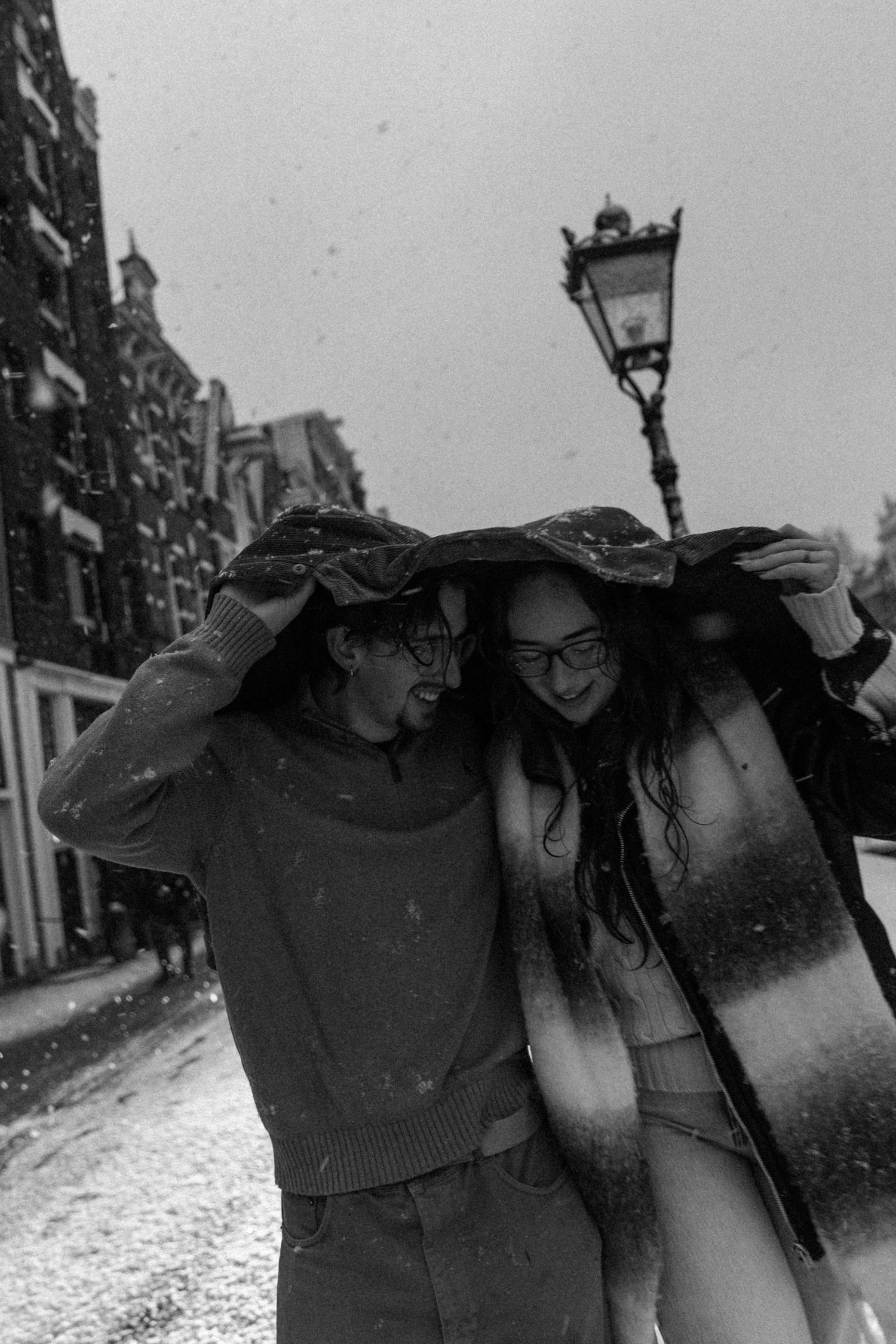 Group walking together in heavy snowfall on Amsterdam street.