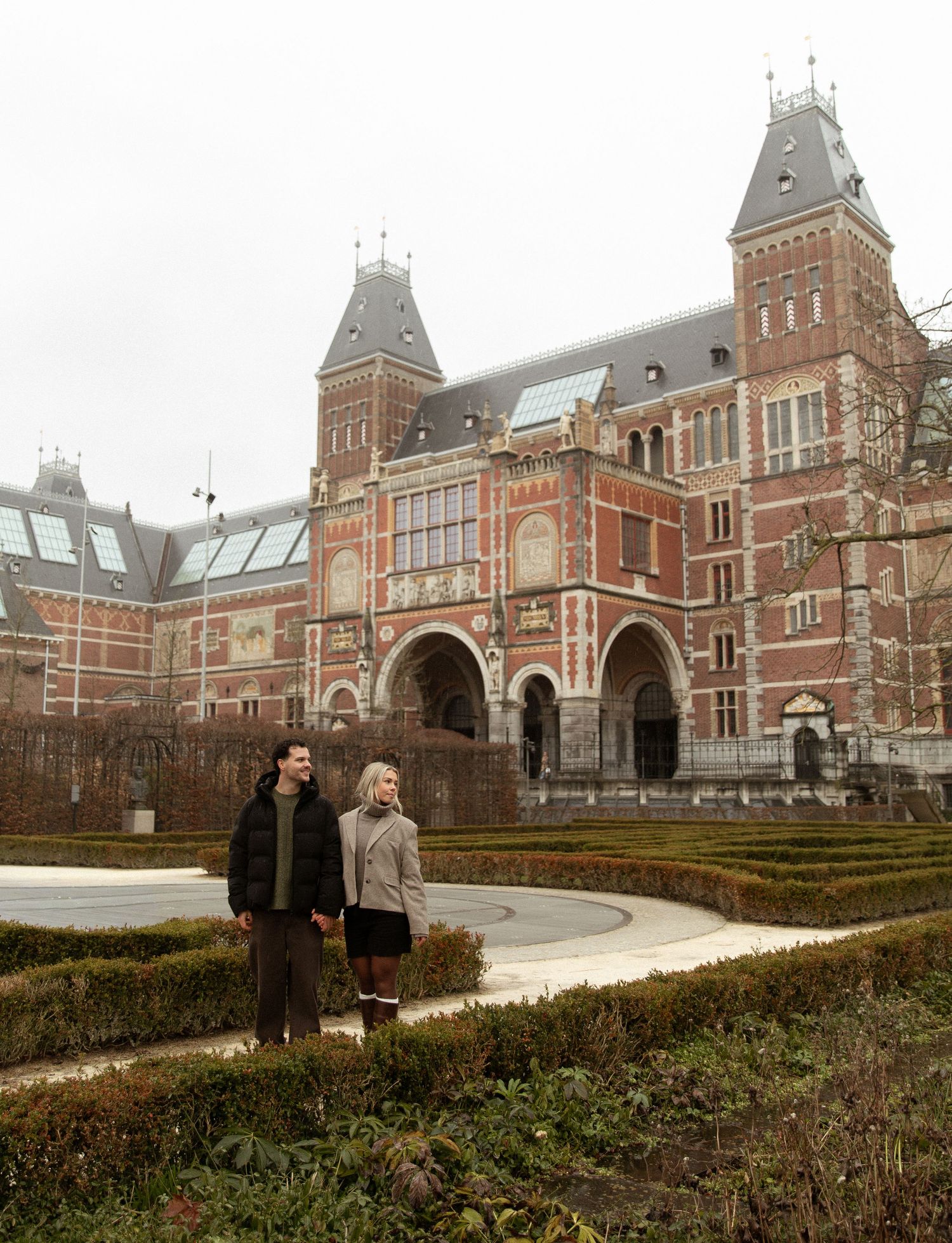 A panoramic view of the historic Rijksmuseum building in Amsterdam with its iconic red brick architecture and archways.