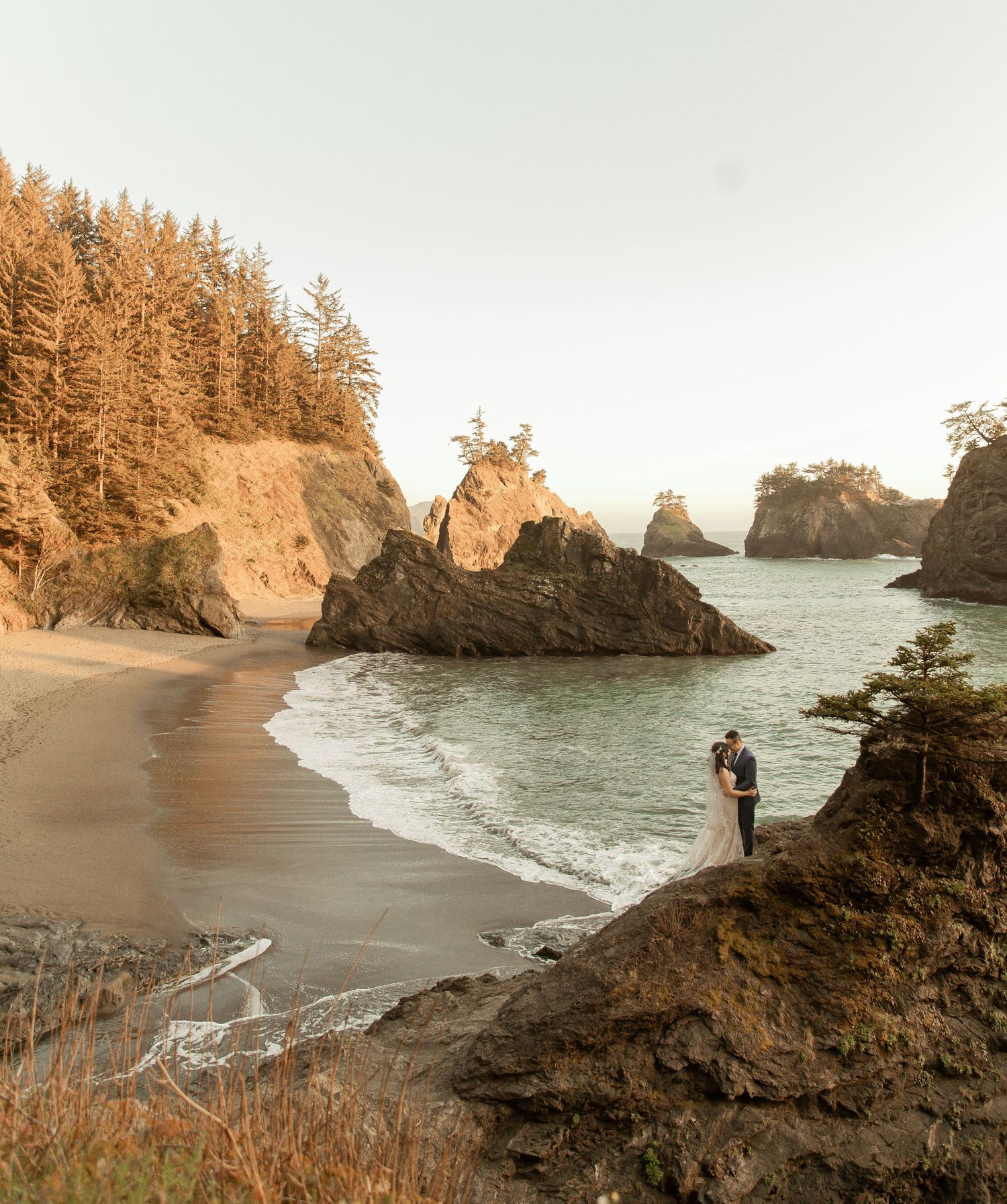 Scenic coastal landscape at sunset with rocky cliffs and beach views.