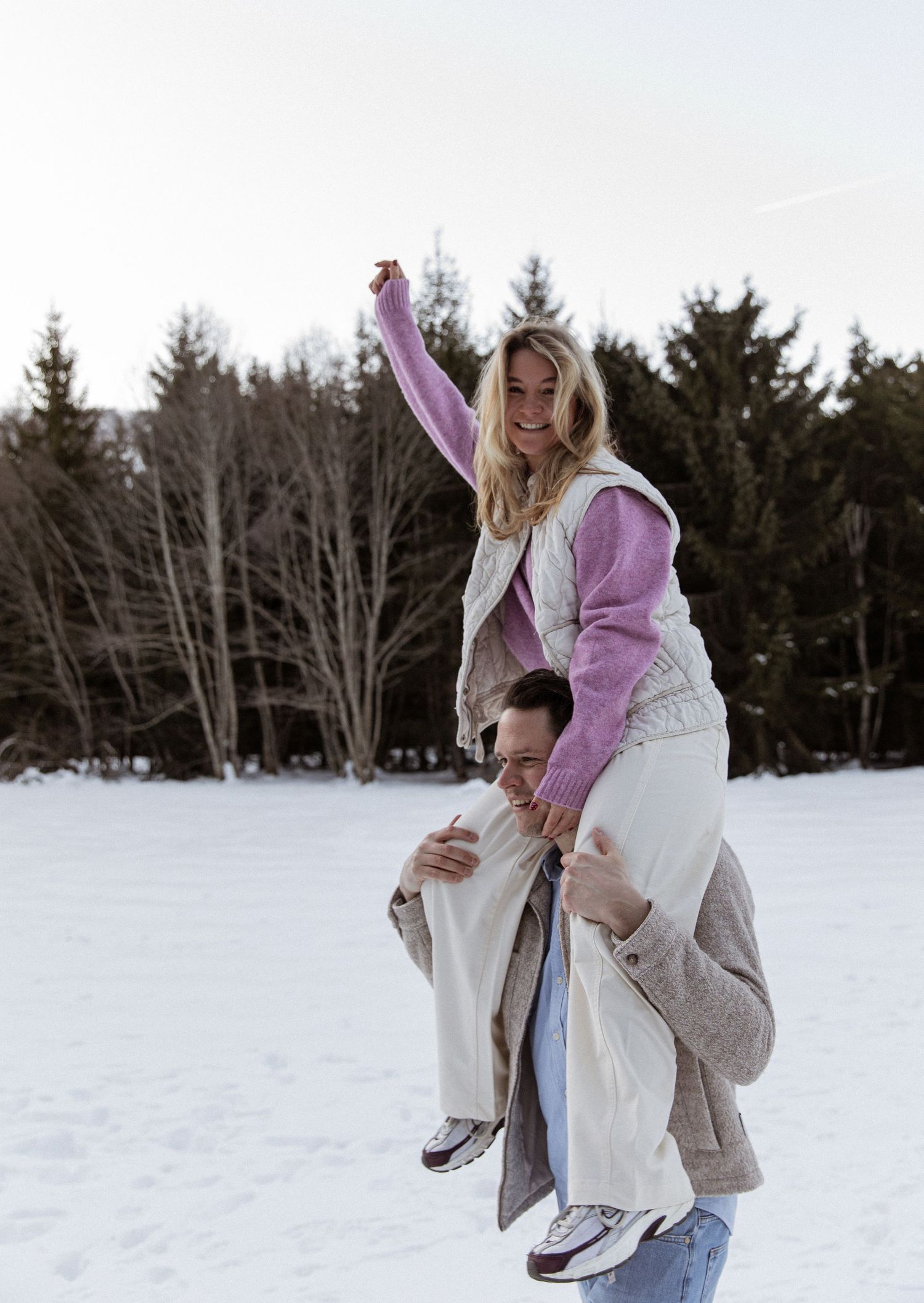 A playful winter scene of two people having fun in the snow.