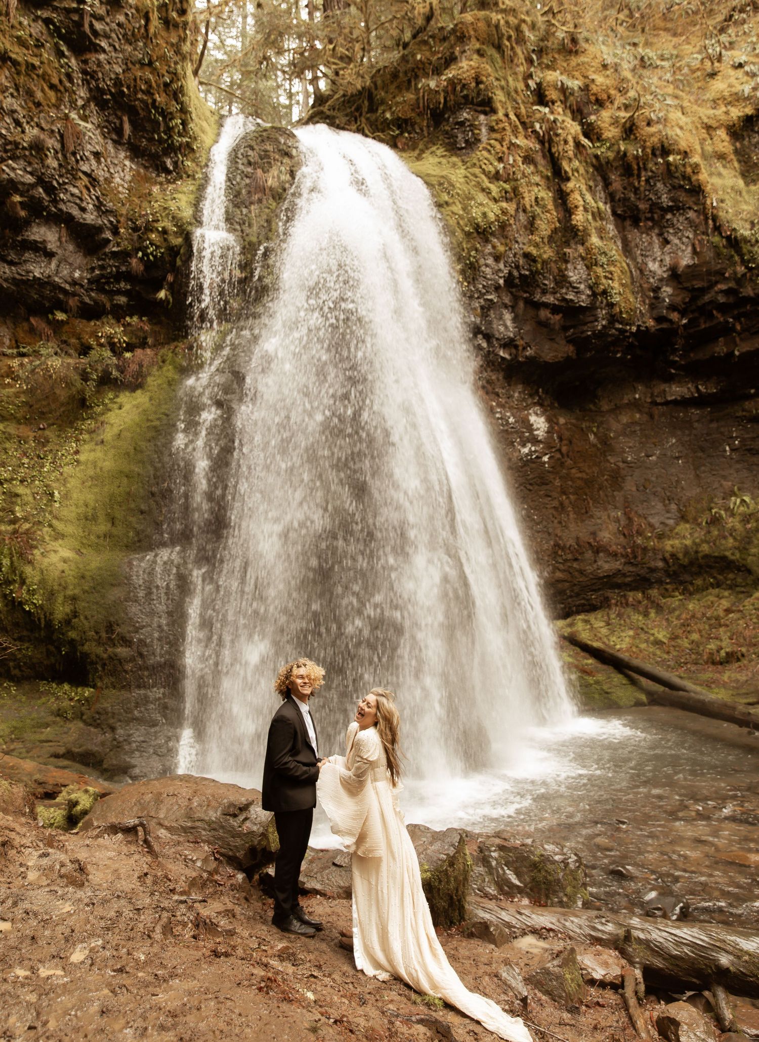 Romantic waterfall photography session with couple in formal wedding attire.