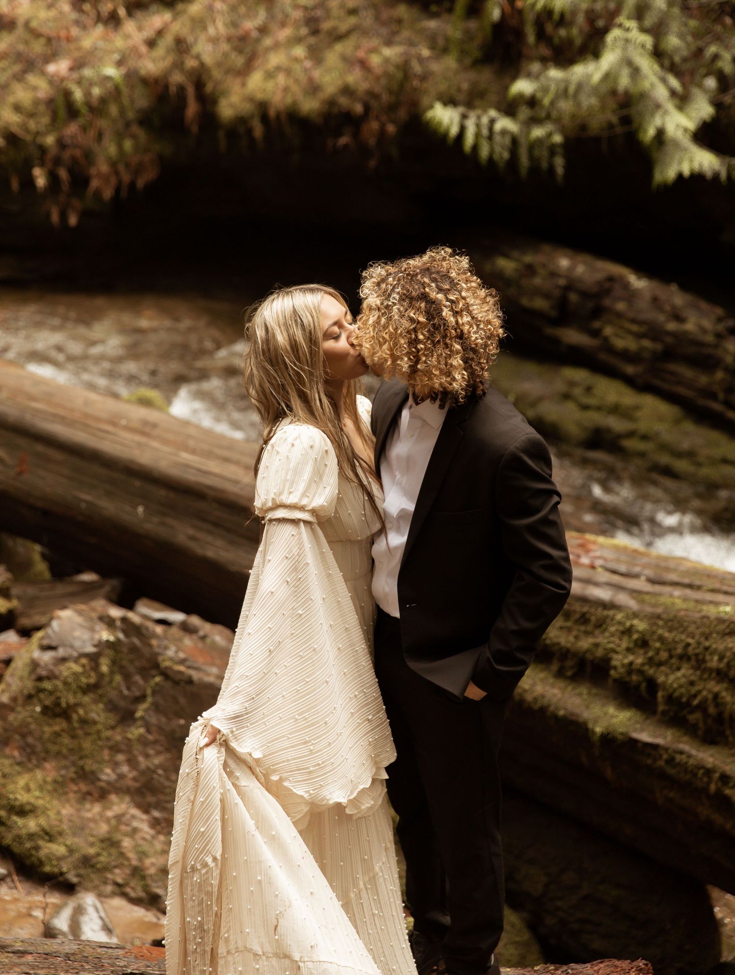 A romantic moment captured in sepia tones against a forest backdrop.