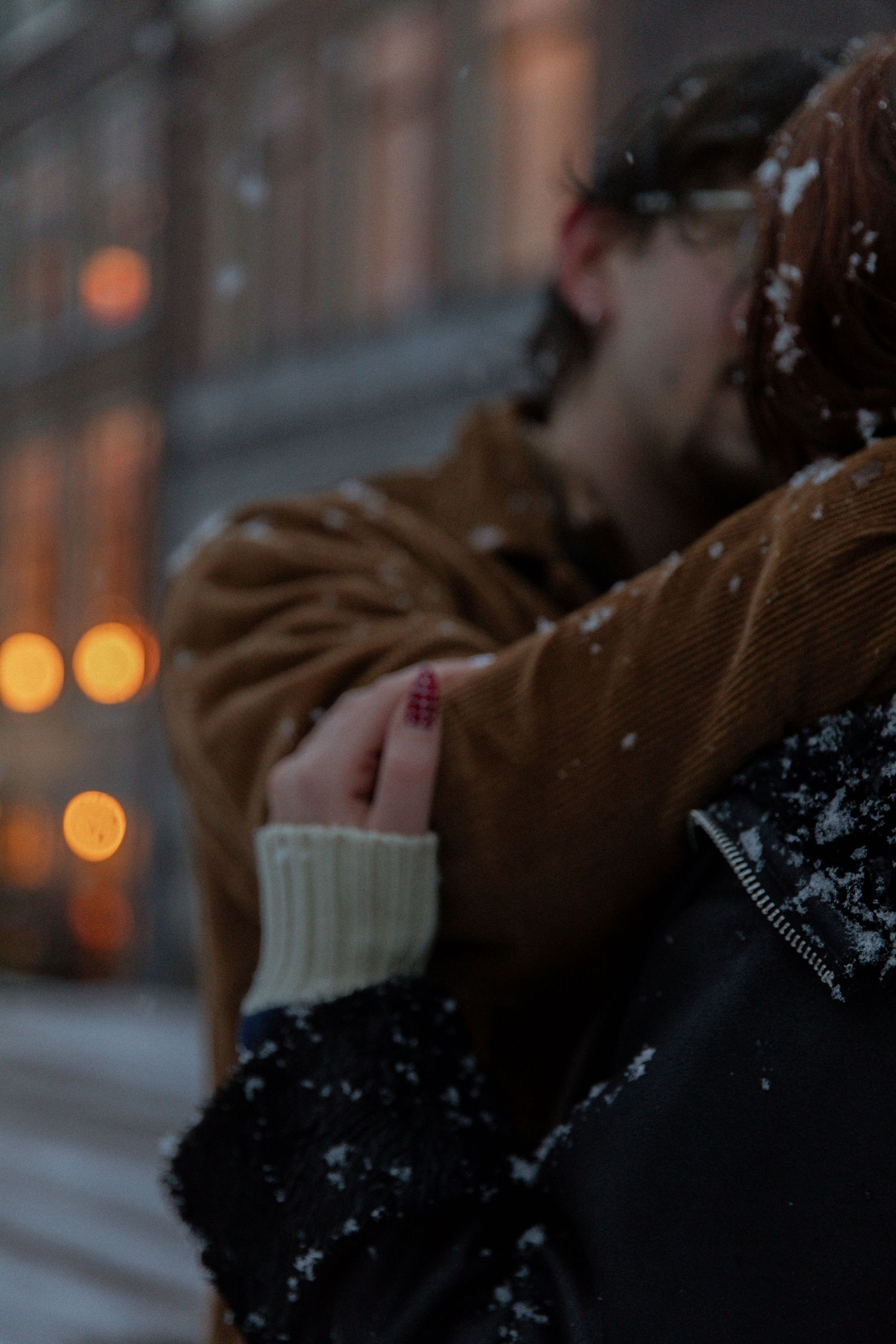 Warm glowing lights illuminate a snowy winter evening in the city.