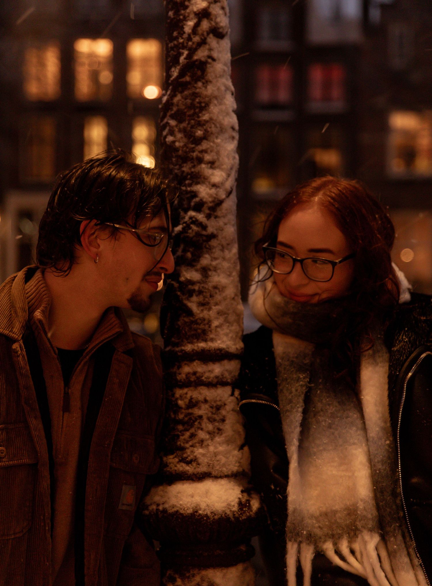 Romantic winter evening scene against snow-covered trees and glowing street lights.