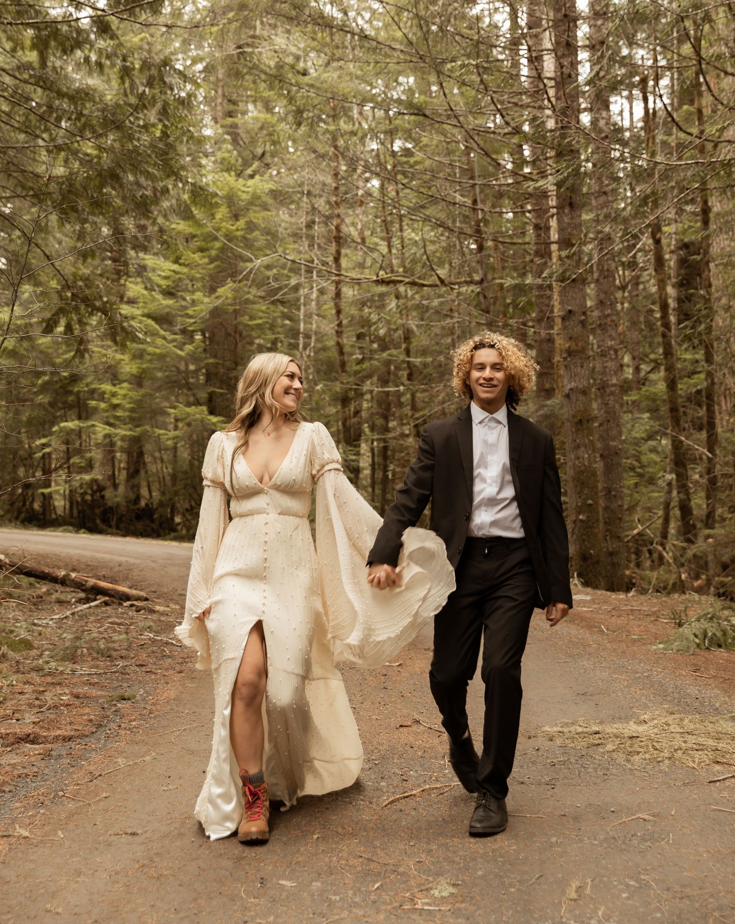 Candid wedding moments captured on a rustic forest path.