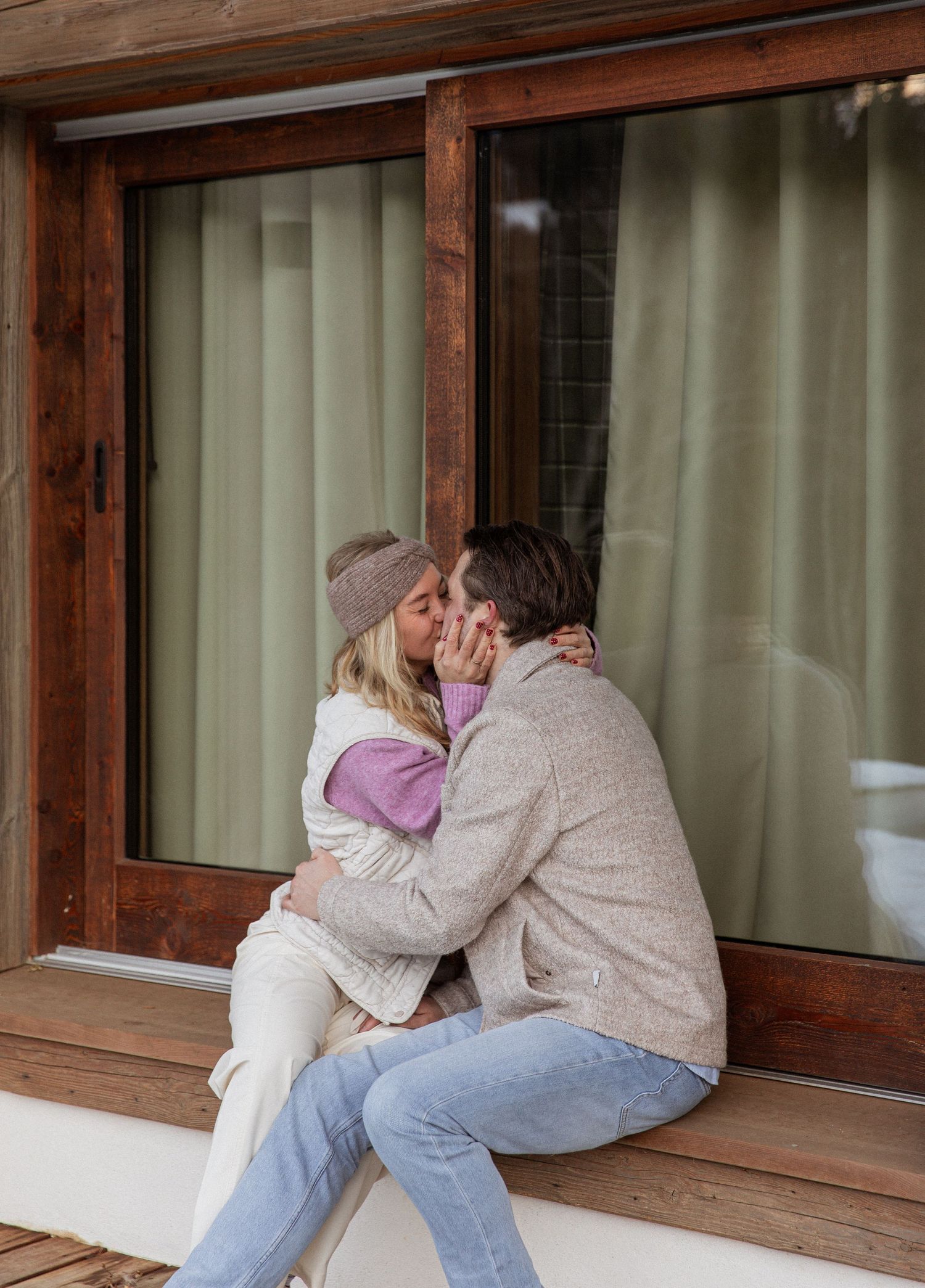 A tender moment shared between two people sitting by a rustic window.