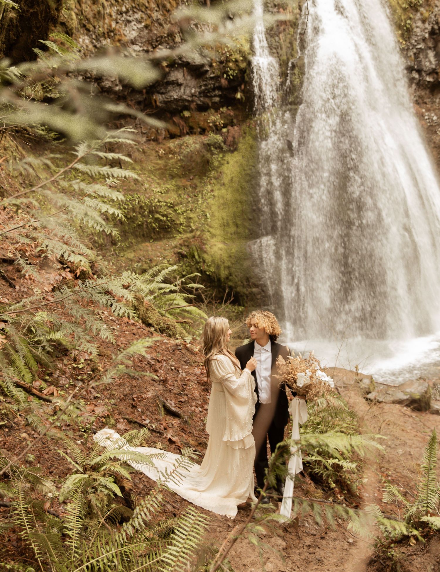 Cascading waterfall provides natural backdrop for intimate forest ceremony.
