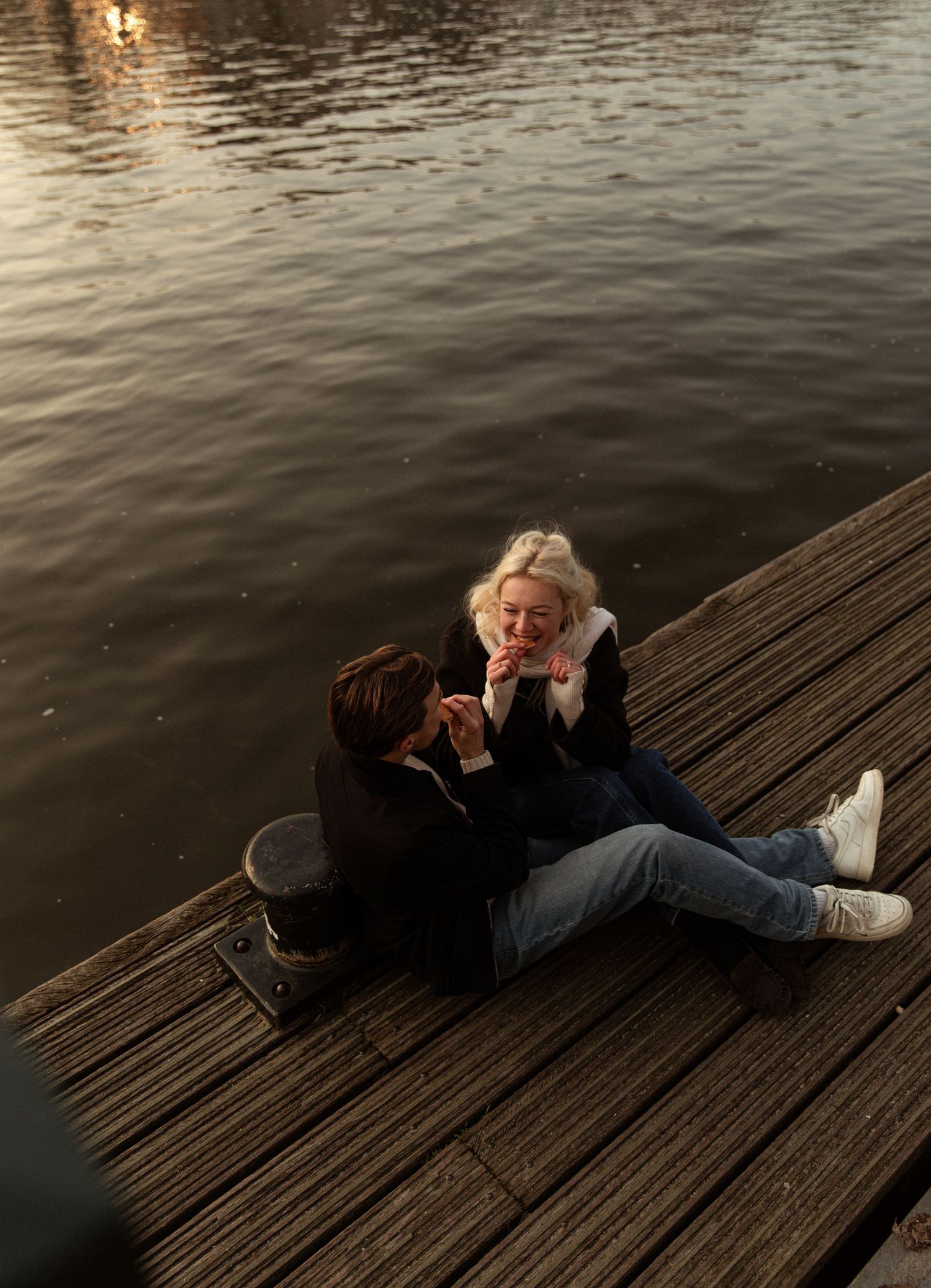 A sequence of images shows someone falling backwards onto a wooden dock by the water in dramatic fashion.