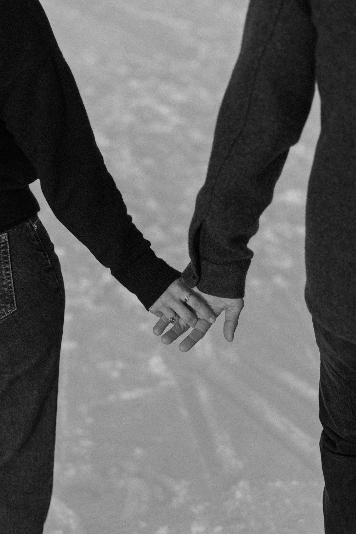 Two hands reaching towards each other in black and white against a textured background.