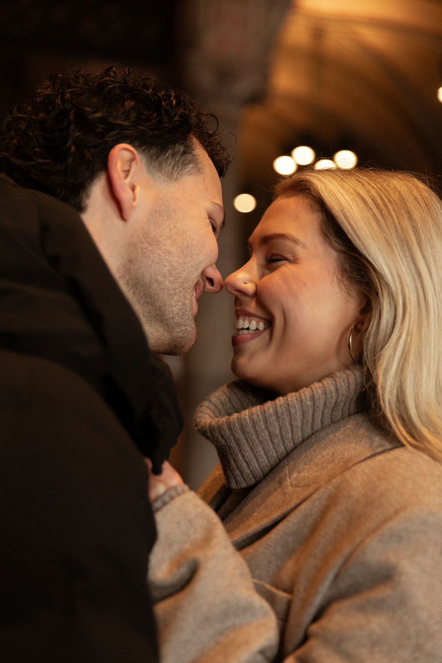 A romantic couple in gray turtleneck sweaters share intimate moments in a series of candid photos.