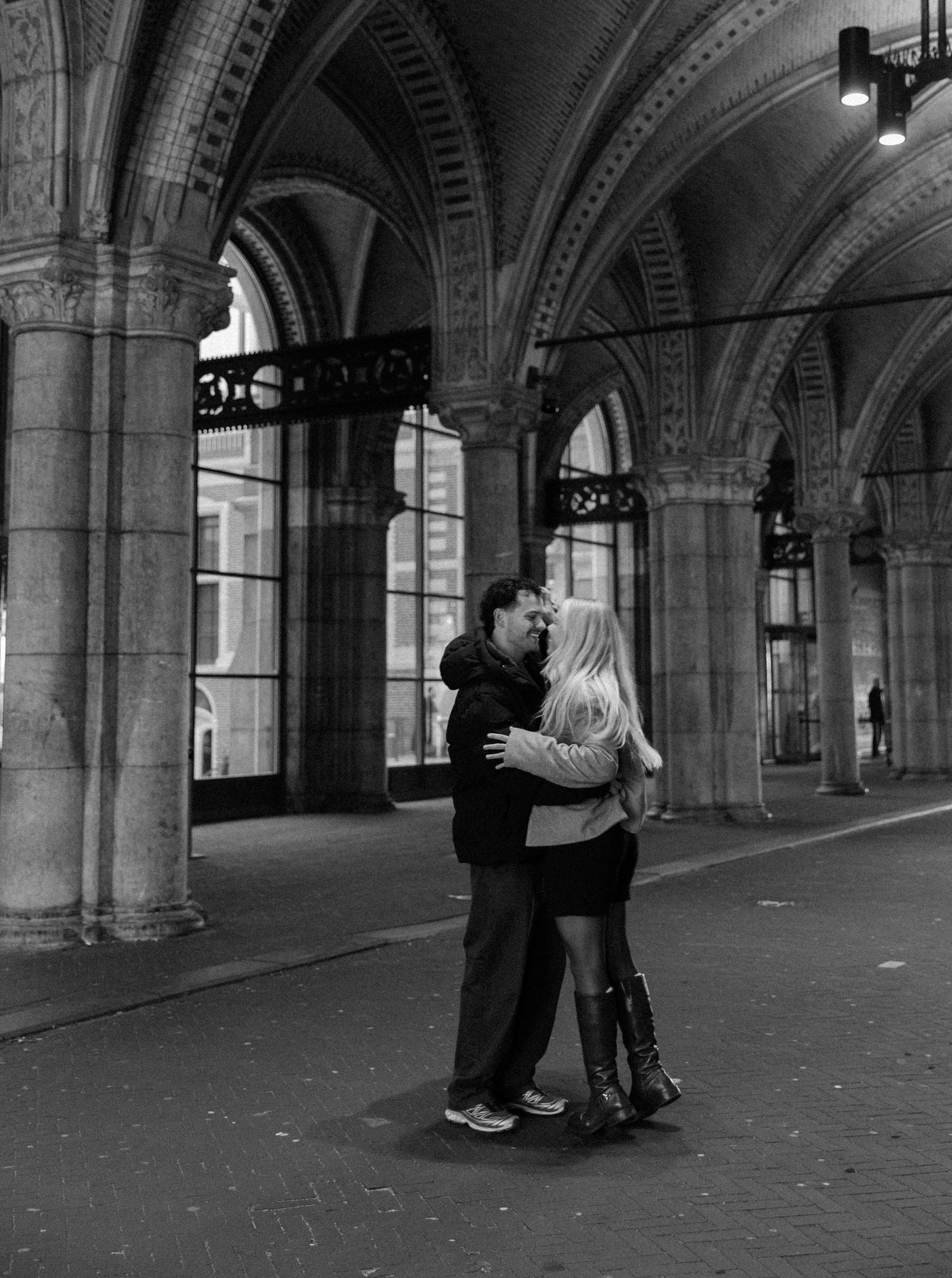 A sequence of black and white photos showing two people dancing in an ornate archway with classical architecture.