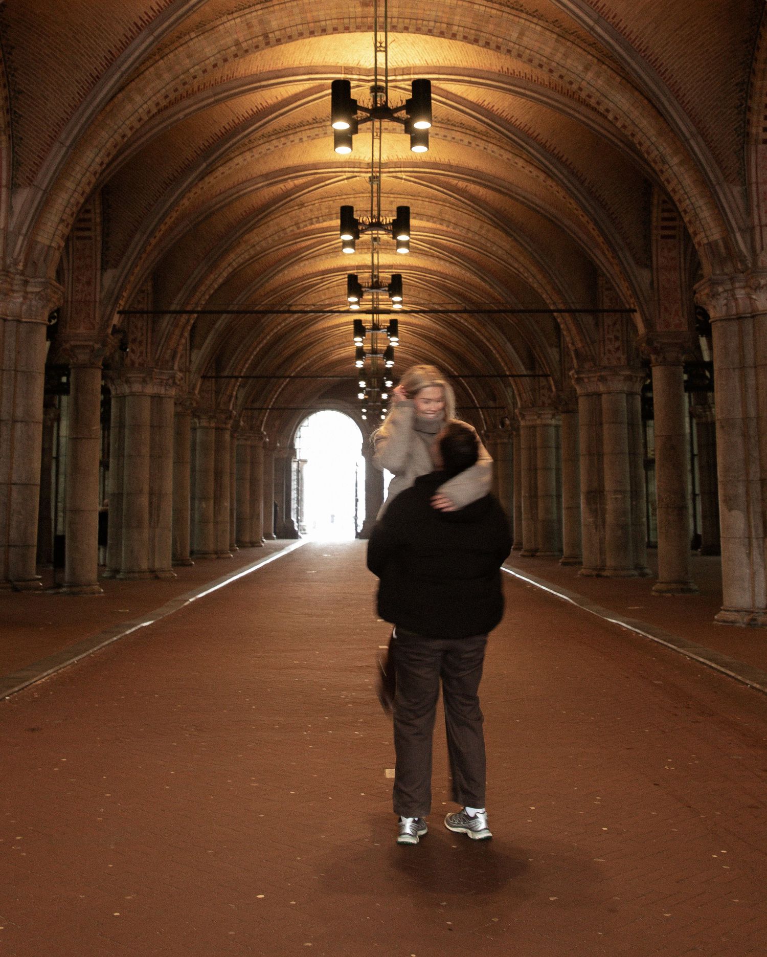 A sequence of four photos shows a person walking through a dimly lit tunnel with arched stone walls and ceiling.