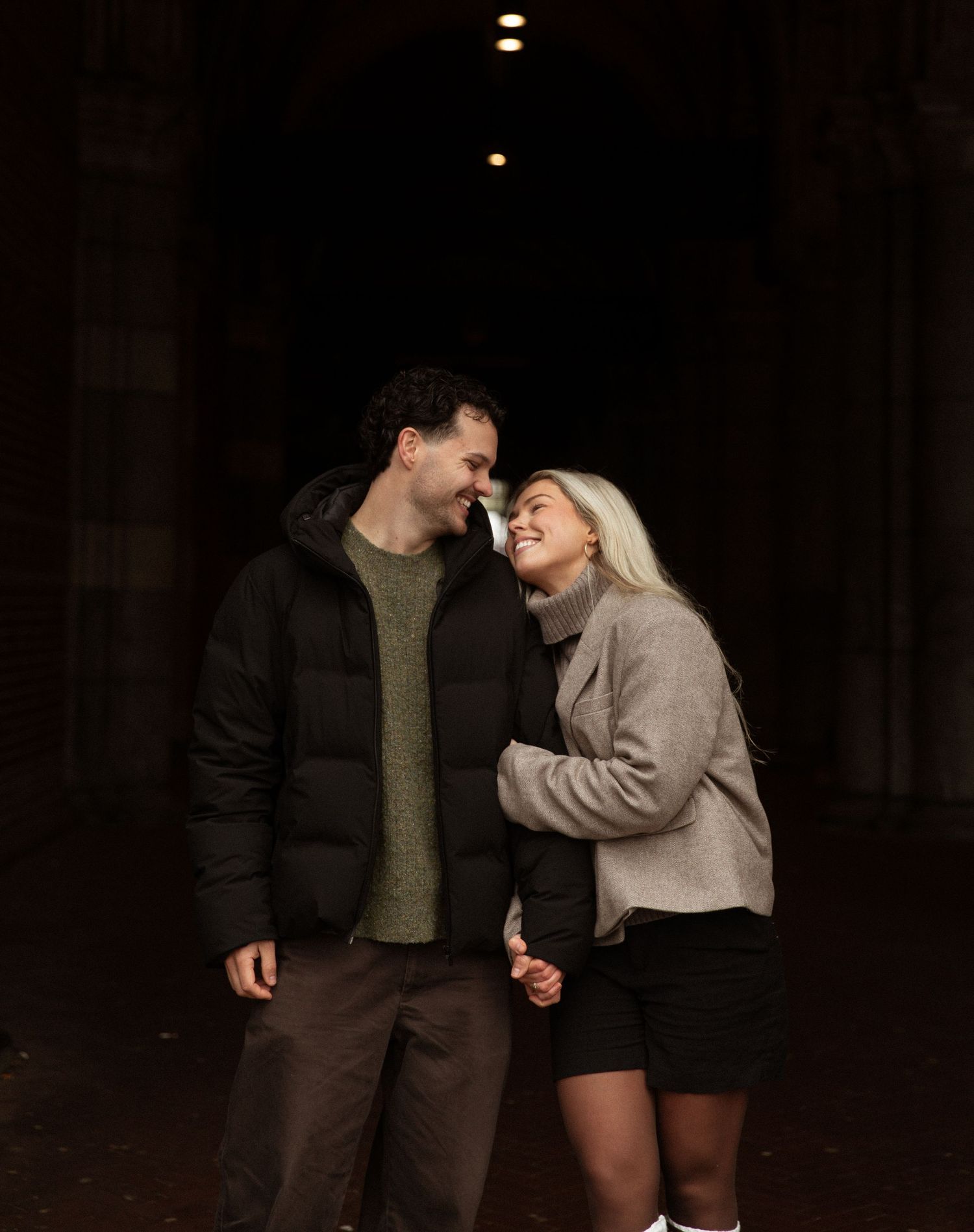 A couple in casual attire shares intimate moments in a sequence of romantic poses against a dark background.