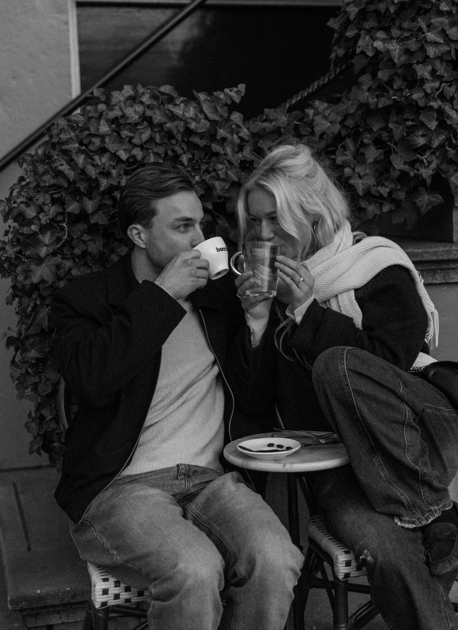 A sequence of vintage black and white photos showing a couple sitting close together on a bench in an intimate moment.