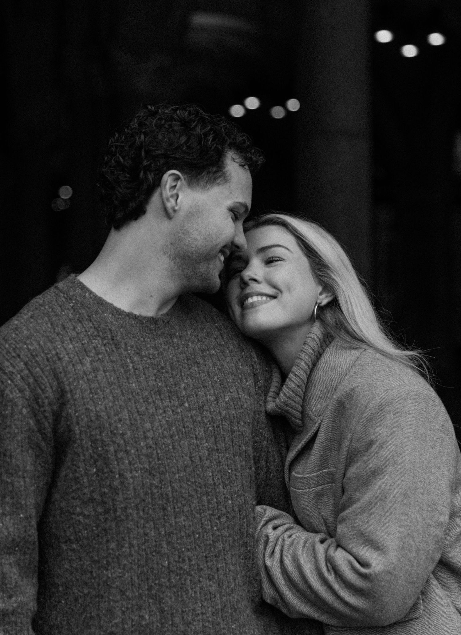 Intimate black and white photo sequence showing a romantic embrace in low lighting.