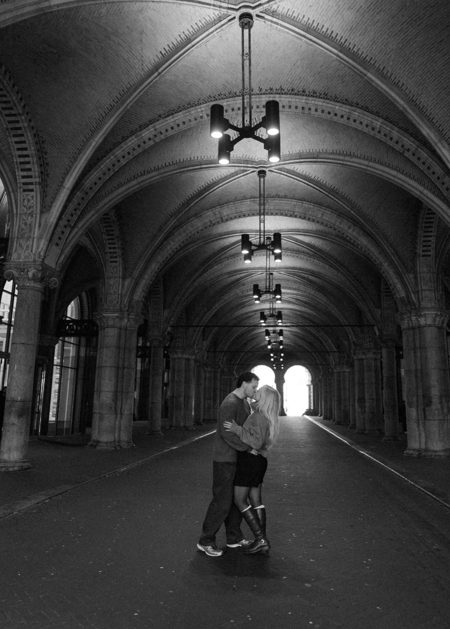 A dramatic black and white photo series showing silhouettes in an arched tunnel with atmospheric lighting.
