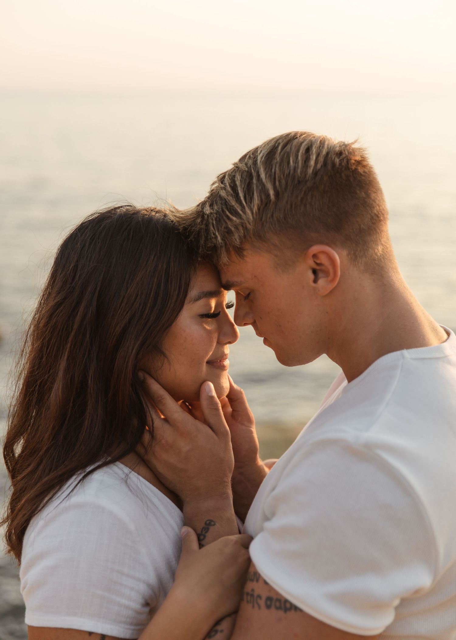 Romantic sunset beach photoshoot showing intimate close-up moments.