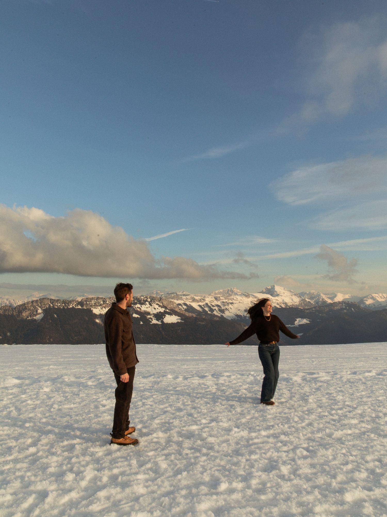 A sequence of panoramic shots shows someone doing backflips in the snow with snowy mountains in the background.